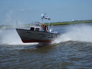 A Goodchild Marine boat with two people riding on it in the water.
Keywords: Goodchild Marine