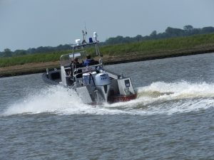 A Goodchild Marine boat with a man driving it on the water.