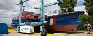A Goodchild Marine boat being lifted by a crane.