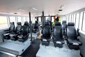 The interior of a Goodchild Marine boat with many seats.