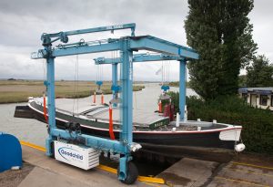 A Goodchild Marine boat is being lifted onto a boat lift.