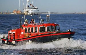 A red and black Goodchild Marine boat in the water.