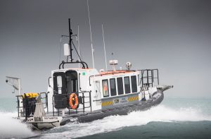 A Goodchild Marine boat sailing in the ocean with a cloudy sky.