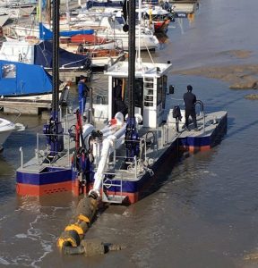 A Goodchild Marine boat docked in the water next to other boats.