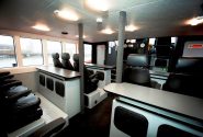 The interior of a Goodchild Marine boat with sleek black seats and tables.