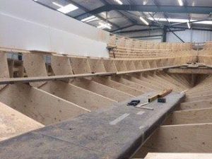 A Goodchild Marine boat being built in a factory.