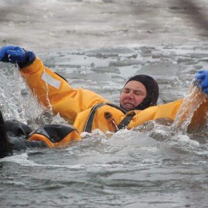 A Goodchild Marine in a yellow suit is floating in the water.